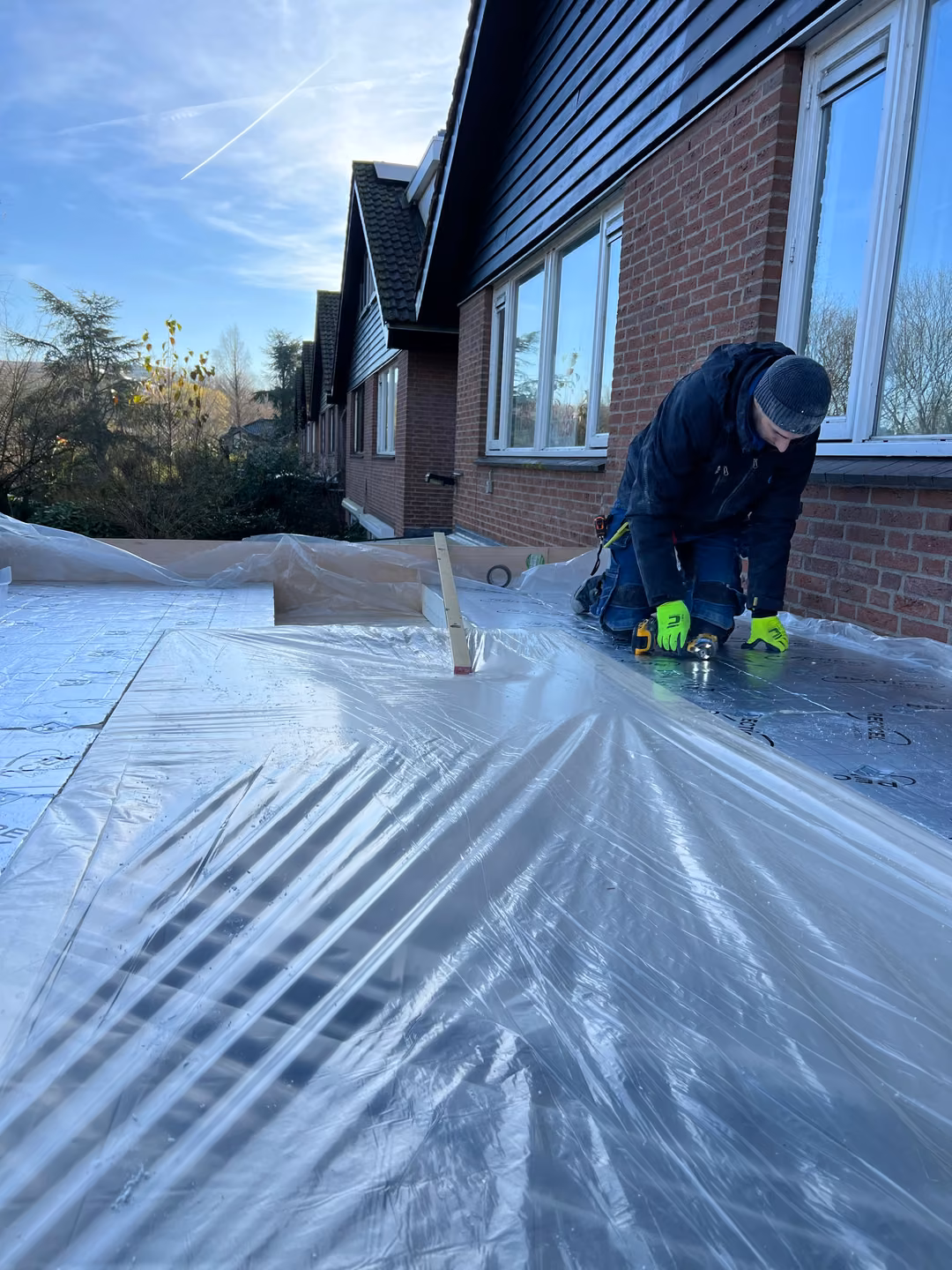 Vakman van HR Huis Renovatie aan het werk op het dak van een uitbouw